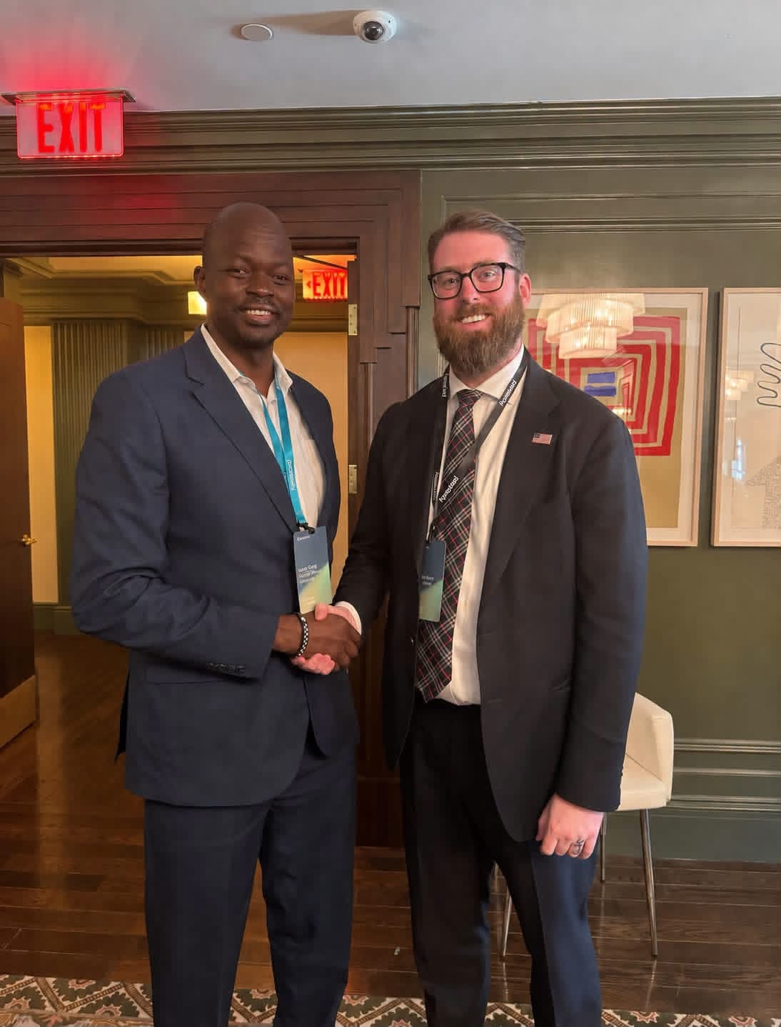 Dr. Isaac Gang and Kaelan Dorr shaking hands at a diplomatic meeting in Washington D.C.